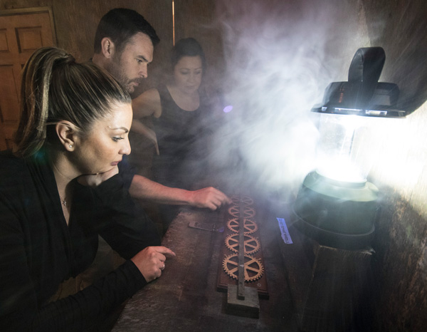 A family working on a puzzle from an escape room scenario called The Cabin at New Mexico Escape Room in Albuquerque, NM